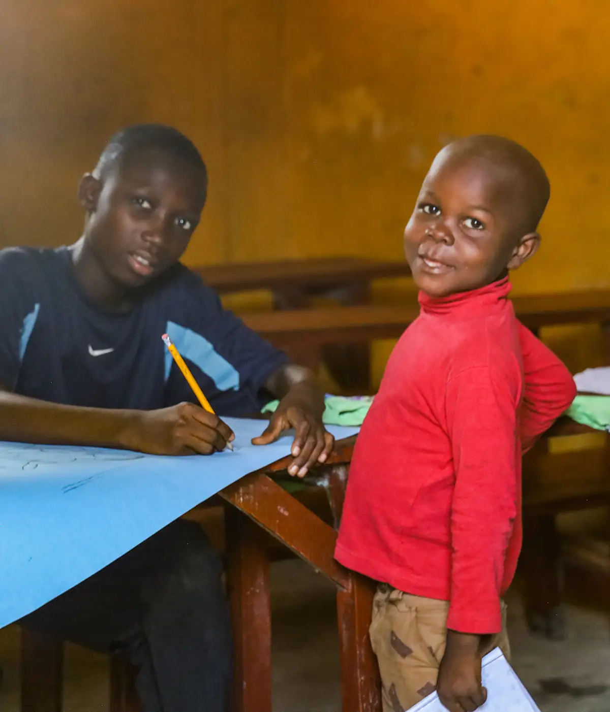 Dos niños en un aula de la escuela de Kingsville; uno de ellos escribe con un lápiz